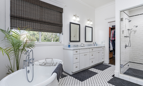 Modern bathroom with white vanity, bathtub, and shower area.